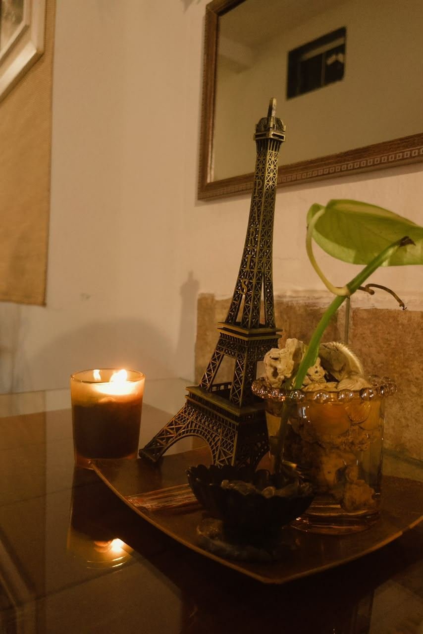 Detalhe de réplica da Torre Eiffel com vela acesa sobre bandeja