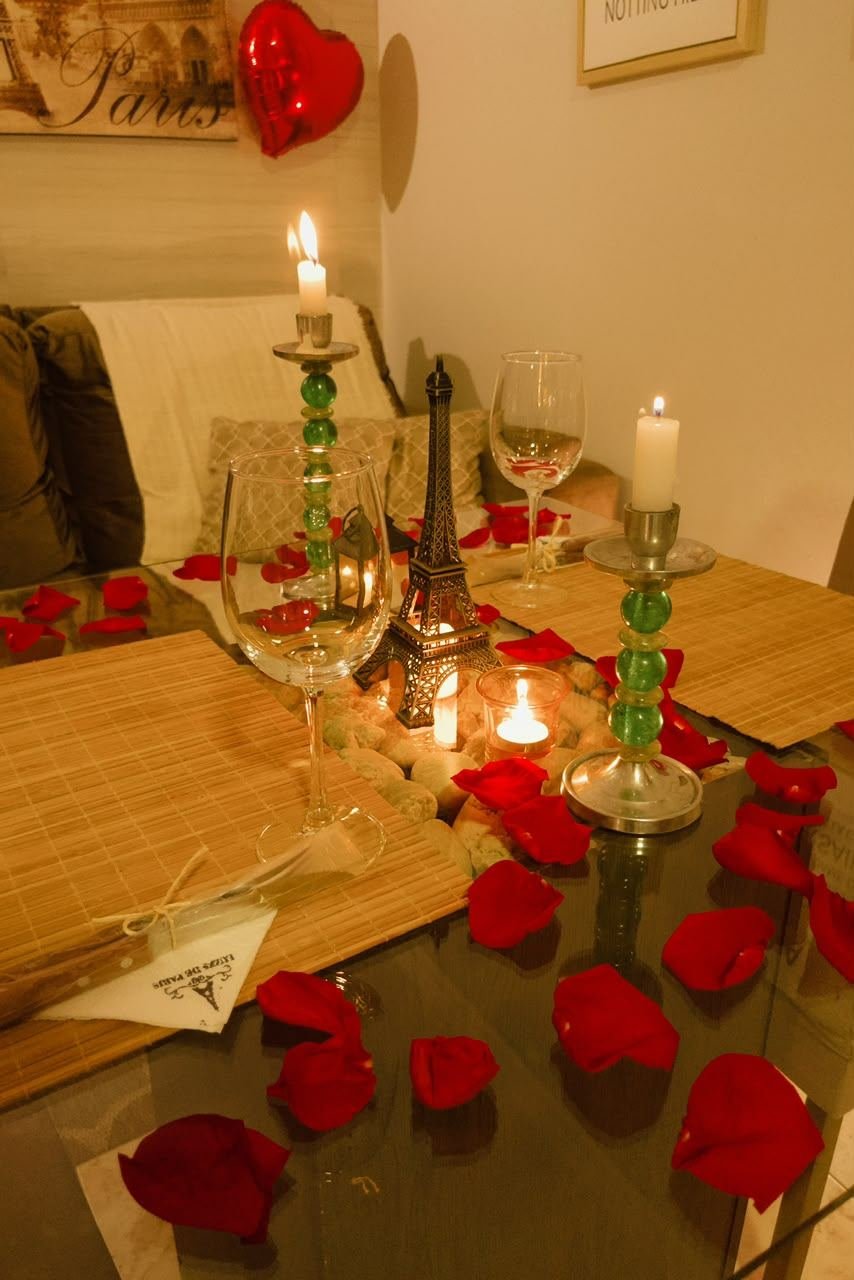 Mesa romântica com velas, rosas e réplica da Torre Eiffel
